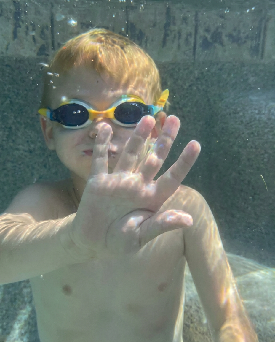 Swim instructor teaching a child to float in the pool